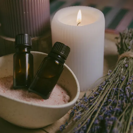 Lahvičky s aroma oleji, svíčka a snítky levandule